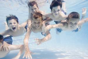 Friends Swimming Underwater in Backyard Pool